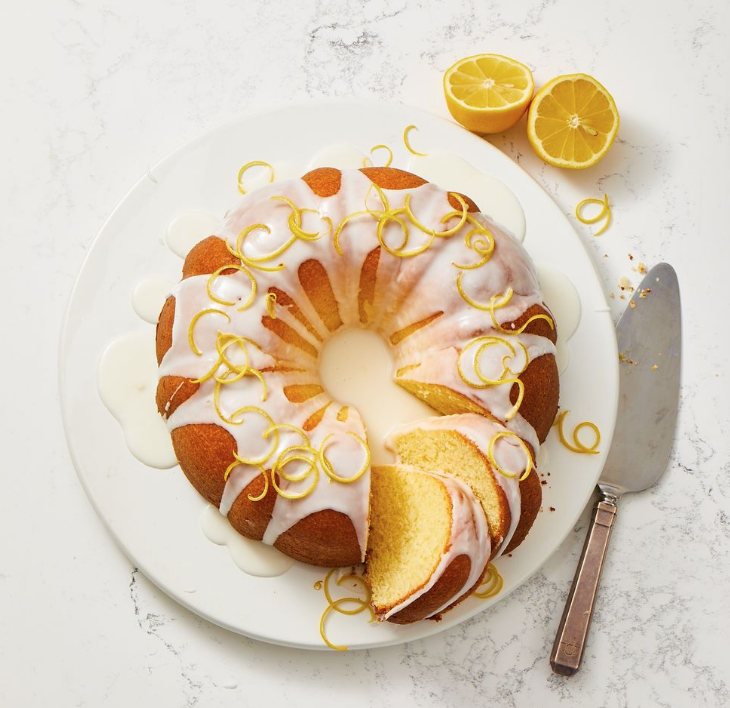 Easy Memorial Day Brunch Recipes by poplar Houston lifestyle blog, Cake and Confetti: image of lemon pound cake on a white plate next to a silver pie server. 