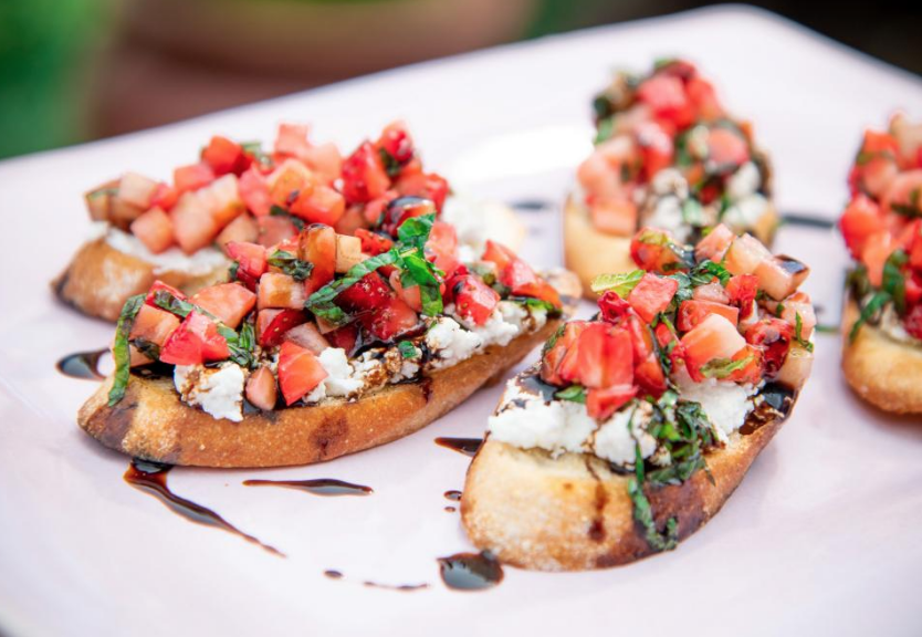Easy Memorial Day Brunch Recipes by poplar Houston lifestyle blog, Cake and Confetti: image of Strawberry Ricotta bruschetta on a white ceramic plate. 