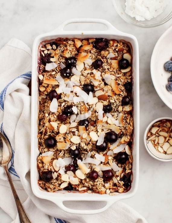 Easy Memorial Day Brunch Recipes by poplar Houston lifestyle blog, Cake and Confetti: image of baked oatmeal with blueberries in a white ceramic baking dish. 