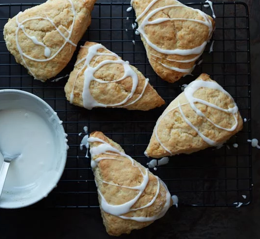 Easy Memorial Day Brunch Recipes by poplar Houston lifestyle blog, Cake and Confetti: image of glazed lemon ginger scones on a black wire cooling rack. 